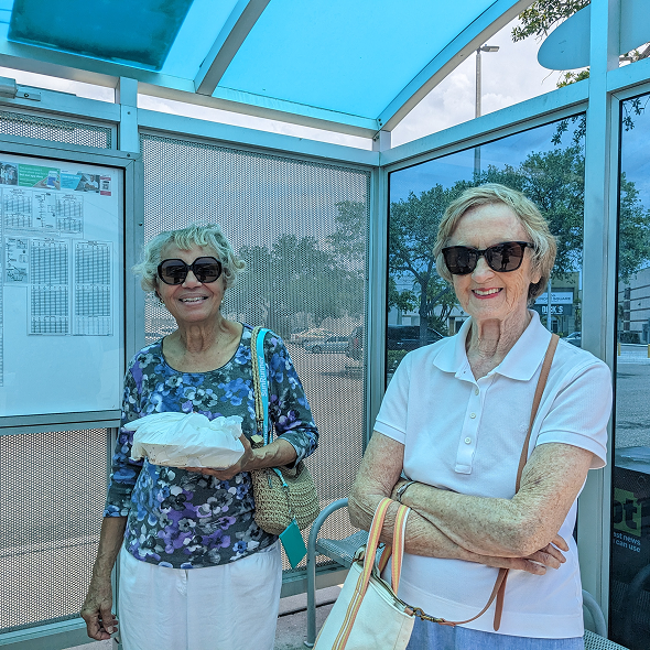 Women standing in shade at bus stop
