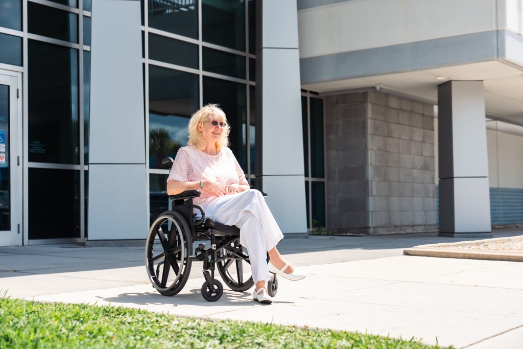 Woman in wheelchair in front of building